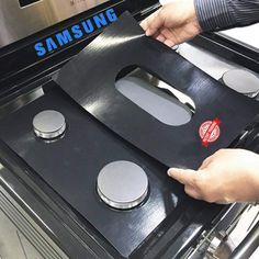 a person is opening the door to an oven with two burners on each side