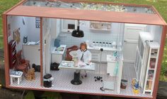 a doll house with a woman in the kitchen