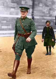 an old photo of a man in uniform walking on the ground with other people behind him