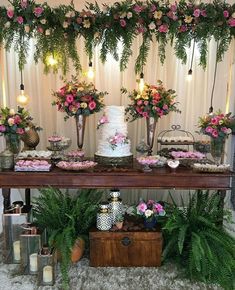 a table topped with lots of different types of cakes and flowers on top of it