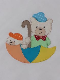 two teddy bears sitting on top of an umbrella