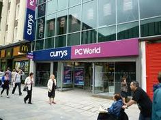 people walking on the sidewalk in front of a mcdonald's and currys world