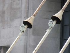 there are two large metal bells on the side of a building that is made of concrete