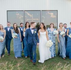 a group of people standing next to each other in front of a building with windows