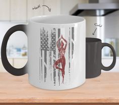 a white and black coffee mug sitting on top of a wooden table next to an american flag