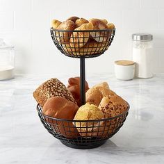 two tiered baskets filled with different types of baked goods on a marble countertop