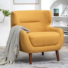 a yellow chair with a blanket on top of it