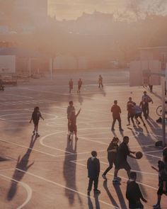 many people are playing basketball on an outdoor court