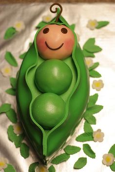 a cake shaped like a peal with two peas in it's pod on a table