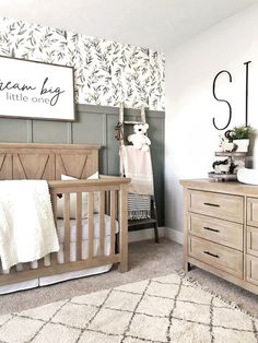 a baby's room with a crib and dresser