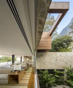 the inside of a house with wooden flooring and stone walls, along with large windows