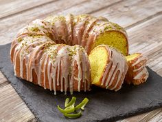 a bundt cake sitting on top of a black slate board next to a slice of green pepper