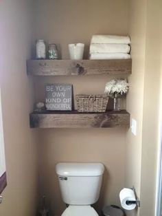 a small bathroom with shelves above the toilet