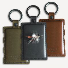 three leather key fobrings with a feather on them