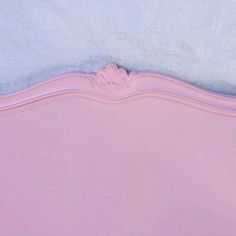 an upholstered pink bed with blue sheets