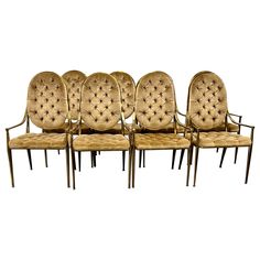 six chairs with gold colored upholstered back and arms are lined up against each other