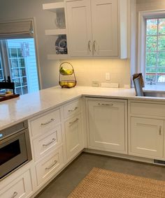 a kitchen with white cabinets and counter tops