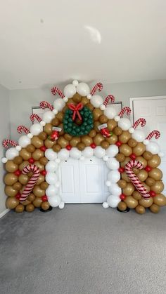 a gingerbread house made out of balloons and candy canes on the front door