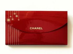 a red envelope with the word chanel on it and gold embellishments