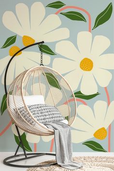 a rattan hanging chair in front of a floral wallpaper