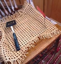 a wooden chair with a crocheted seat pad and a knife on top of it