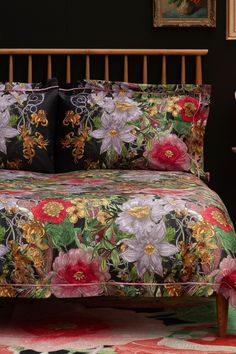 a bed with floral bedspread and matching pillows