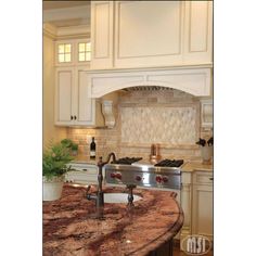 a kitchen with marble counter tops and white cabinets