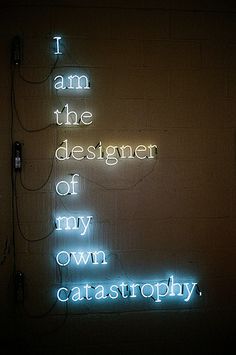 a neon sign that says i am the designer of my own catastrophy