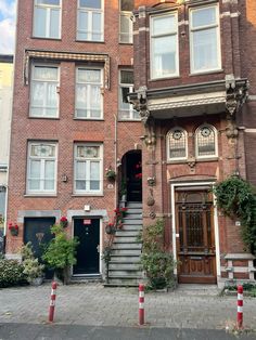 an apartment building with stairs leading up to the front door and windows on either side