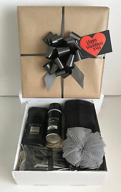 an open gift box with some items in it and a red heart on the top