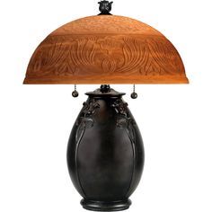 a black vase with a wooden base underneath a lamp