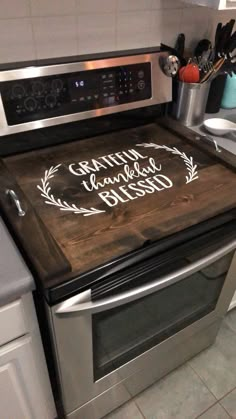 a wooden cutting board sitting on top of an oven with the words faith, family and bliss written on it