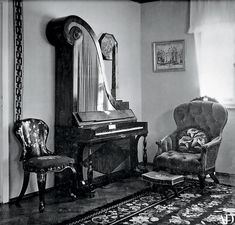 an old piano and chair in a living room