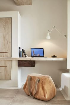 a desk with a laptop on it and a wooden object in front of the monitor