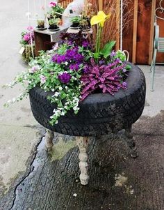 a tire planter filled with flowers and plants