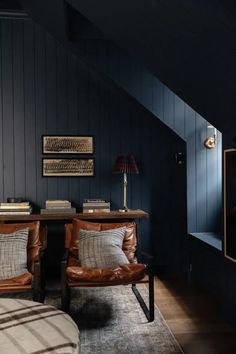 a living room with two leather chairs and a wooden table