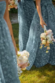 the bridesmaids are holding their bouquets and walking together in blue lace dresses