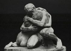 a black and white photo of two people hugging on a stone slab with the word love written below it