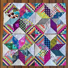 a colorful patchwork quilt on top of a wooden table