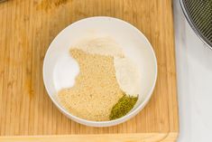 a white bowl filled with spices on top of a wooden cutting board