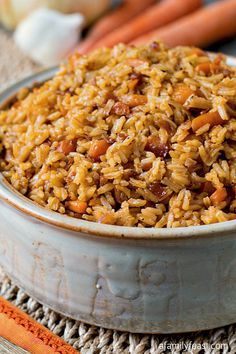 a bowl filled with rice and carrots on top of a table