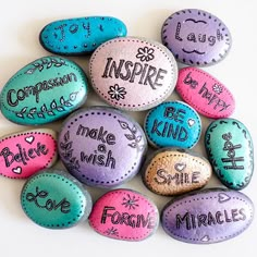 painted rocks that say inspire, be kind and smile