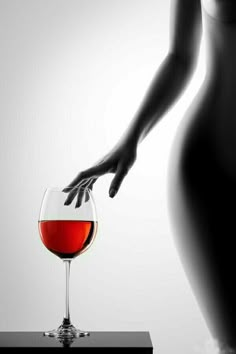 a woman's hand reaching for a glass of wine