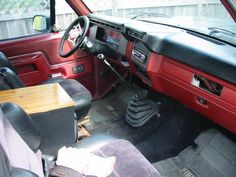 the interior of a car with black leather seats and wood table in front of it