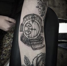 a black and white photo of a person with a tattoo on their arm that has an image of a door