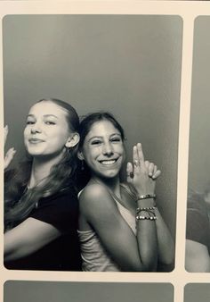 two girls are posing for the camera with their hands in the air and one girl is smiling