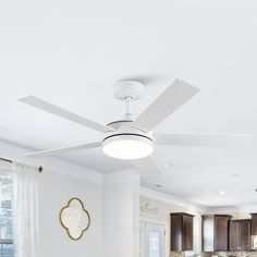 a white ceiling fan in the middle of a kitchen