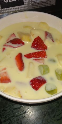 a white bowl filled with fruit on top of a table