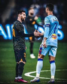 two soccer players shake hands on the field