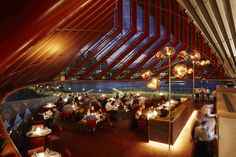 the inside of a restaurant with red chairs and tables in front of a large window